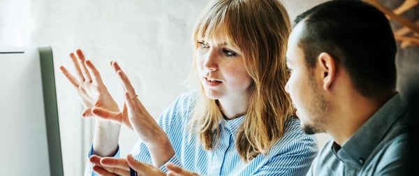 The Now of Work -- a woman is explaining something happening on a monitor to a man sitting next to her